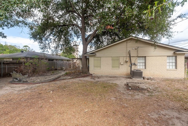 6215 Westgate Dr, Beaumont, TX 77706 - rear view of property with brick siding and central AC