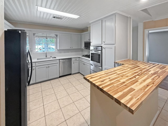 6215 Westgate Dr, Beaumont, TX 77706 - kitchen featuring appliances with stainless steel finishes, a sink, light tile patterned floors, a warming drawer, and gray cabinets