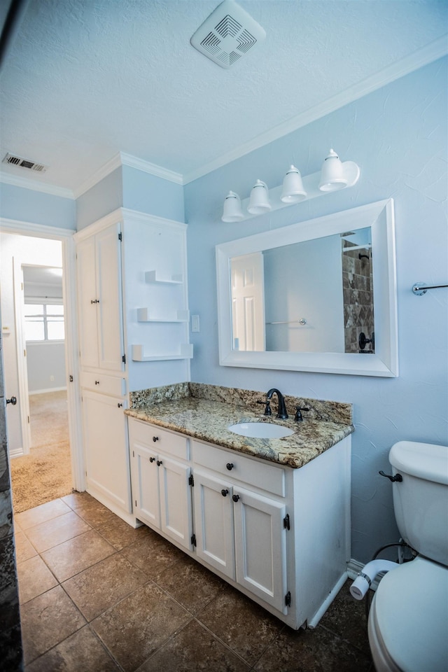 bathroom featuring vanity, ornamental molding, and toilet