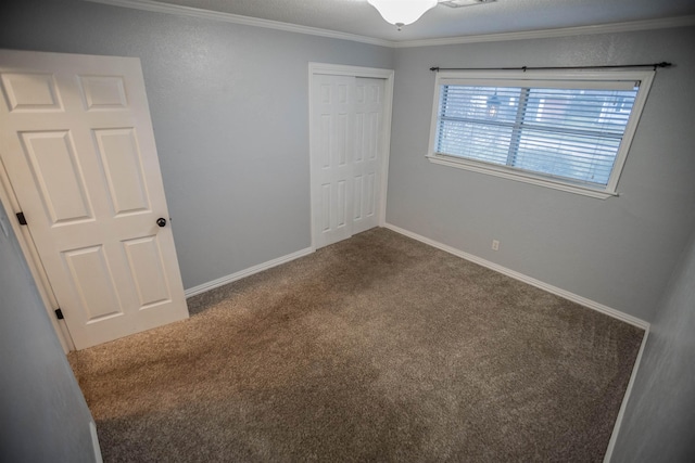 unfurnished bedroom with carpet flooring, crown molding, and a closet