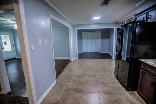 corridor with ornamental molding and light tile patterned flooring