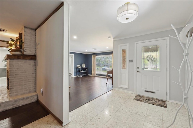 foyer with ornamental molding and baseboards