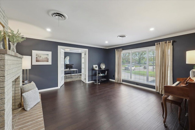 living area with ornamental molding, wood finished floors, baseboards, a fireplace, and recessed lighting