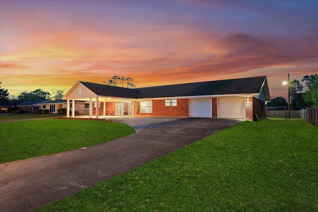 ranch-style home featuring asphalt driveway, an attached garage, and brick siding