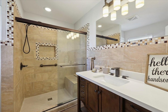 bathroom featuring a stall shower, tile walls, vanity, recessed lighting, and backsplash