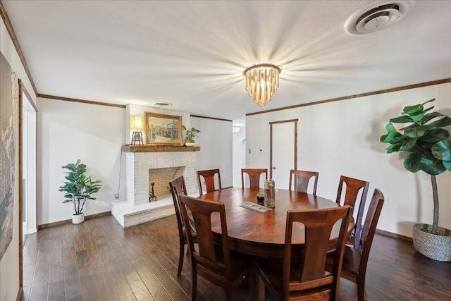 dining area with wood finished floors, a fireplace, baseboards, and crown molding