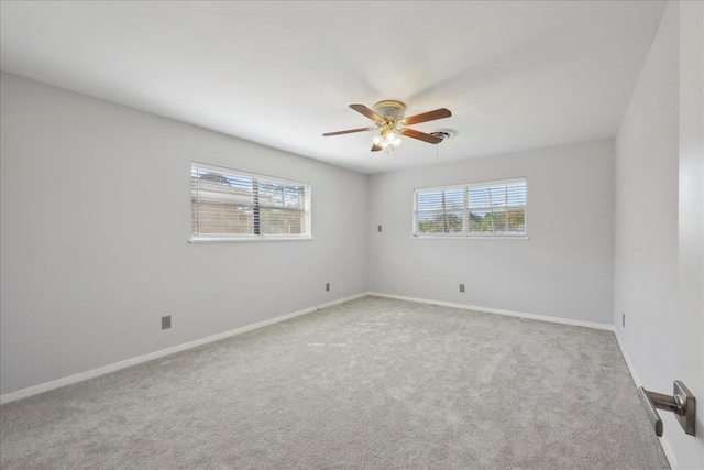 empty room with ceiling fan, carpet, and baseboards