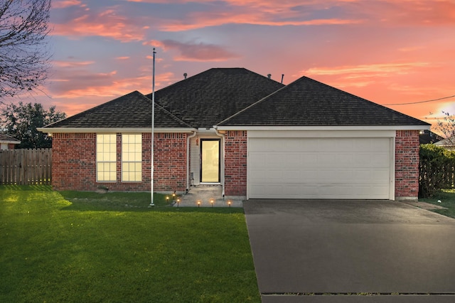 ranch-style house featuring a yard and a garage