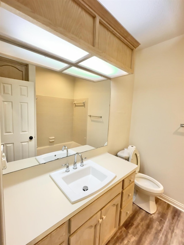 bathroom with hardwood / wood-style floors, vanity, and toilet