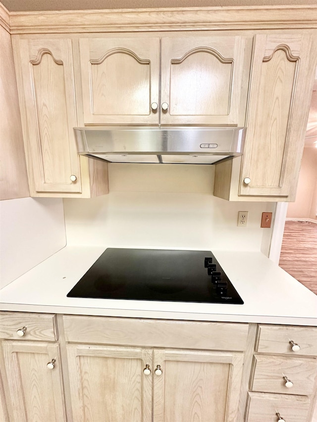 kitchen featuring light brown cabinets, black electric cooktop, and exhaust hood