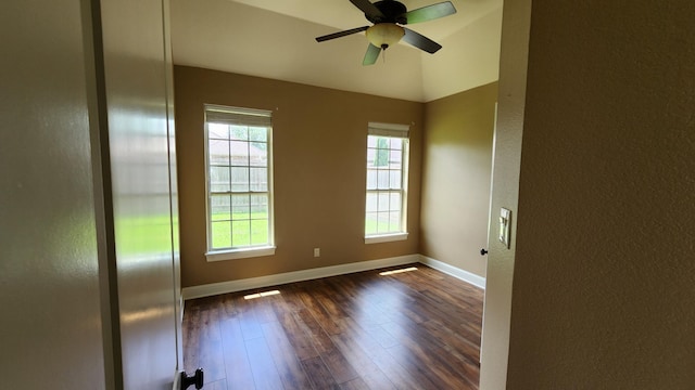 empty room featuring baseboards, a textured wall, and dark wood-style floors