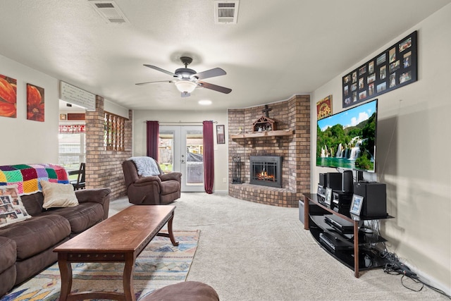 carpeted living room with visible vents, a fireplace, a textured ceiling, and ceiling fan