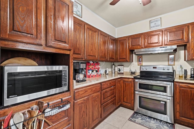 kitchen with ceiling fan, under cabinet range hood, light countertops, light tile patterned floors, and appliances with stainless steel finishes