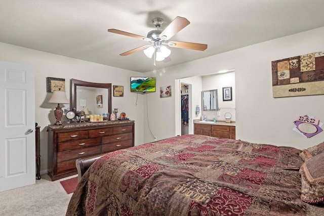 bedroom with connected bathroom, a ceiling fan, and light carpet