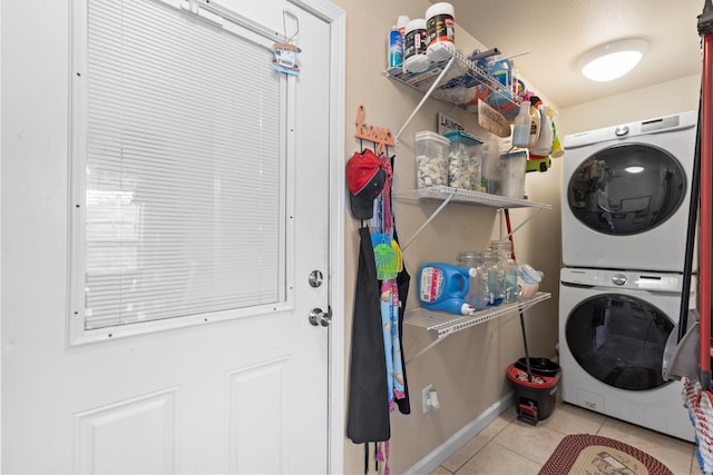 laundry area with tile patterned flooring, laundry area, and stacked washer / drying machine