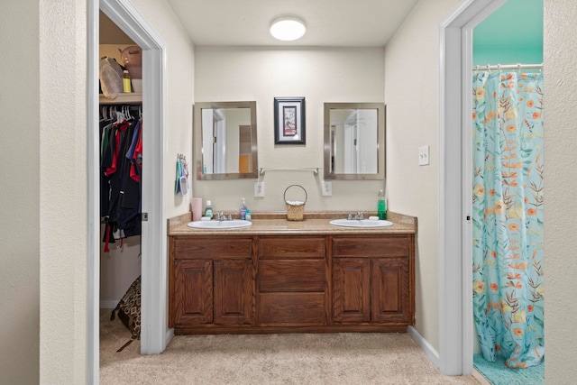 full bathroom with a sink, a shower with shower curtain, a spacious closet, and double vanity