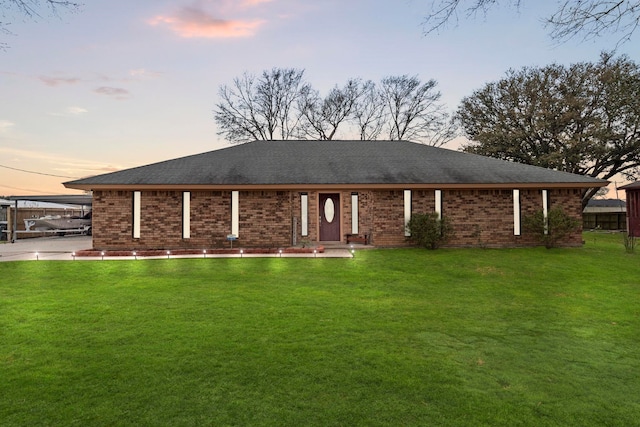 ranch-style house with a yard and brick siding