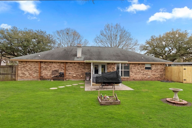 rear view of house with a patio, brick siding, and a fenced backyard