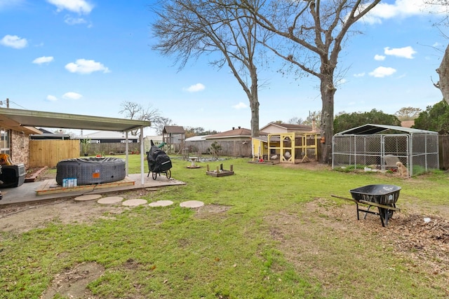 view of yard featuring an outbuilding, a fenced backyard, and a hot tub