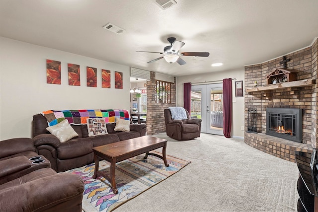 carpeted living area with visible vents, a brick fireplace, a ceiling fan, and french doors