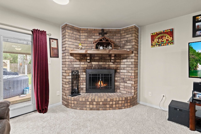 carpeted living room with a brick fireplace and baseboards