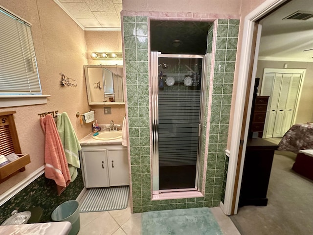 bathroom with tile patterned floors, vanity, an enclosed shower, and ornamental molding