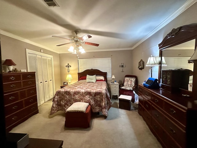 carpeted bedroom featuring ceiling fan, a closet, and crown molding