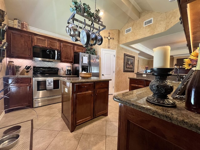 5770 Scenic Dr, Beaumont, TX 77713 - kitchen with appliances with stainless steel finishes, a center island, beam ceiling, tasteful backsplash, and light tile patterned floors