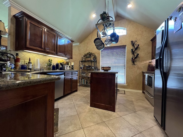 5770 Scenic Dr, Beaumont, TX 77713 - kitchen with appliances with stainless steel finishes, vaulted ceiling, dark brown cabinets, tasteful backsplash, and light tile patterned flooring