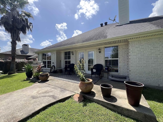 5770 Scenic Dr, Beaumont, TX 77713 - back of property with a patio area, brick siding, roof with shingles, and a chimney