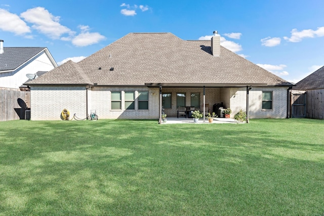 rear view of house featuring a patio area and a yard