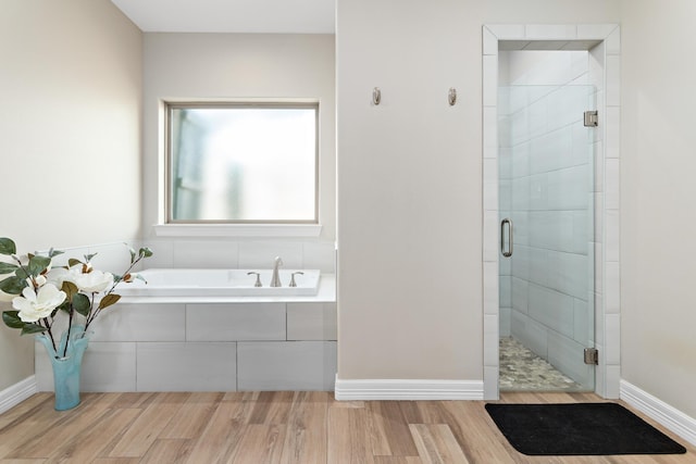 bathroom featuring hardwood / wood-style floors and separate shower and tub