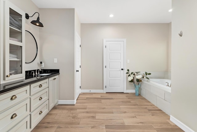 bathroom featuring vanity and a relaxing tiled tub