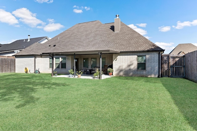 back of house with a yard and a patio