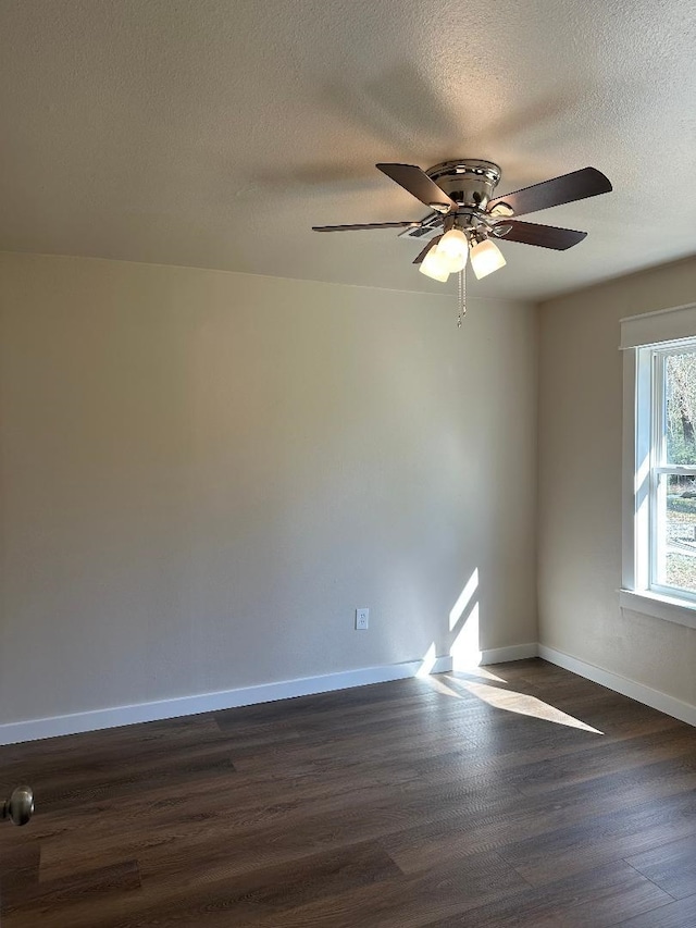 unfurnished room with ceiling fan, dark wood-type flooring, baseboards, and a textured ceiling