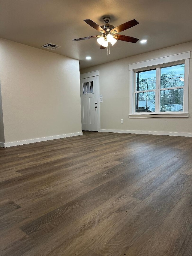 empty room with dark wood finished floors, recessed lighting, visible vents, and baseboards