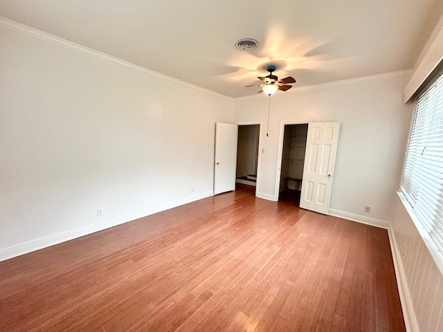 unfurnished bedroom with hardwood / wood-style floors, a closet, ceiling fan, and ornamental molding