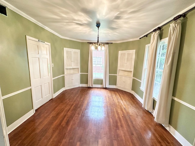 unfurnished dining area featuring a chandelier, dark wood-type flooring, and ornamental molding