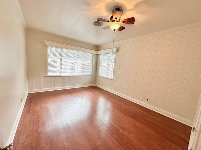 unfurnished room with hardwood / wood-style floors, ceiling fan, and crown molding