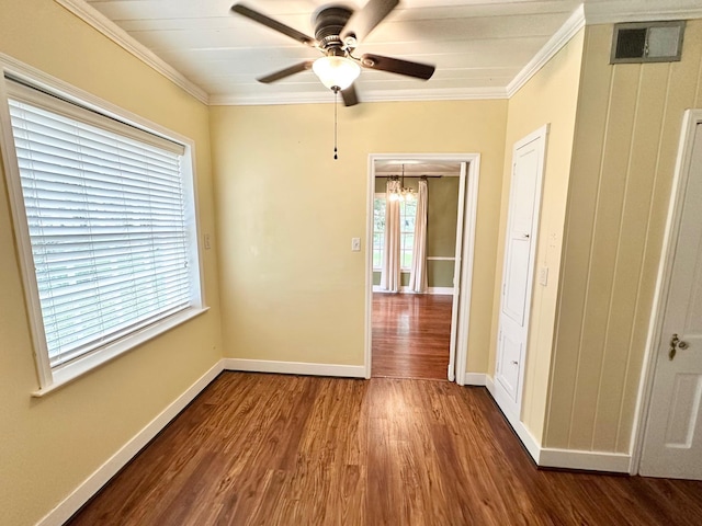 spare room featuring hardwood / wood-style flooring, ceiling fan with notable chandelier, and crown molding