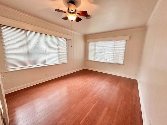 spare room featuring hardwood / wood-style floors, ceiling fan, and ornamental molding