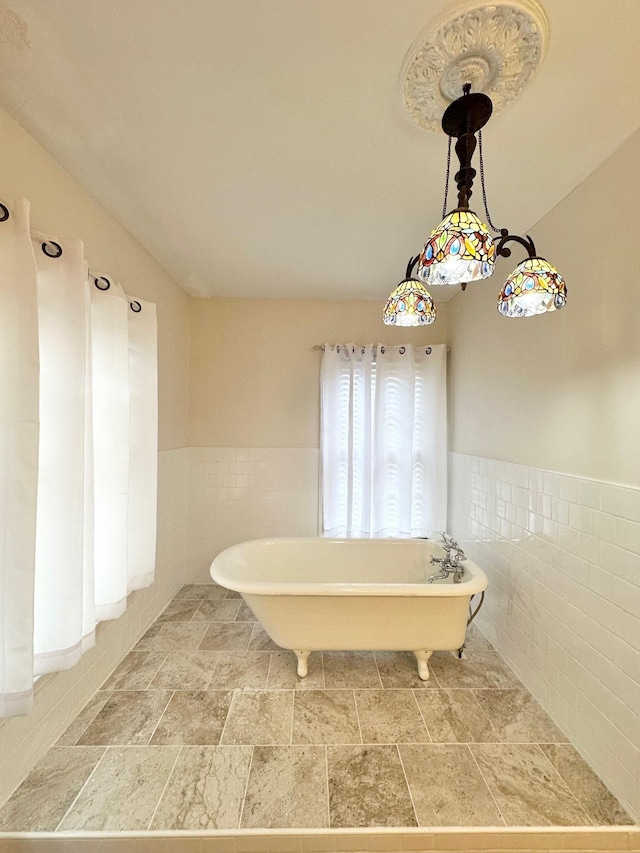 bathroom with a bathing tub and tile walls