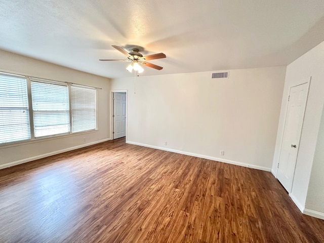 empty room with dark hardwood / wood-style floors and ceiling fan