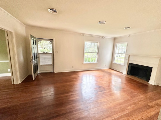 unfurnished living room with ornamental molding, dark hardwood / wood-style flooring, and a healthy amount of sunlight