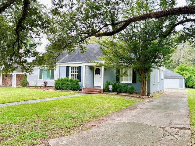 view of front of house featuring a garage, a front lawn, and an outdoor structure