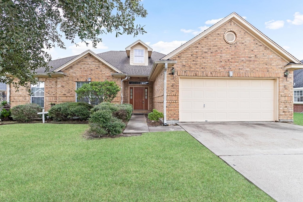 view of property featuring a garage and a front lawn