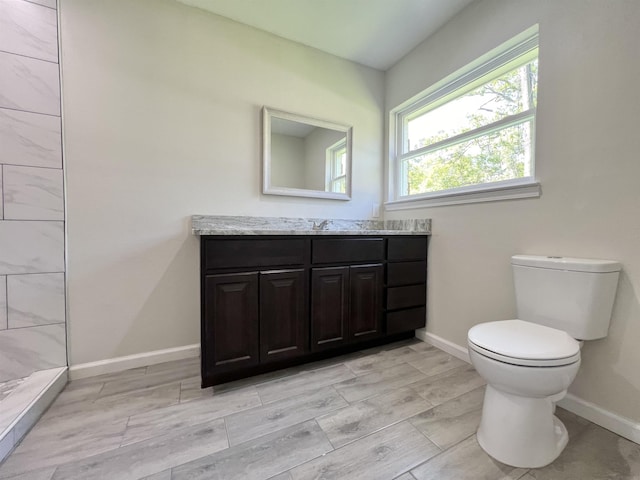 bathroom with walk in shower, vanity, and toilet