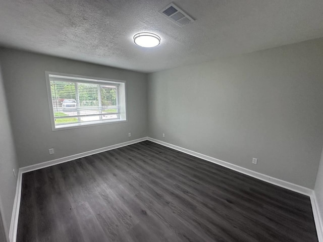 unfurnished room featuring a textured ceiling and dark hardwood / wood-style floors