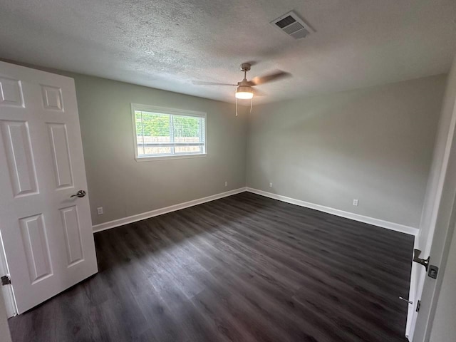 spare room with ceiling fan, a textured ceiling, and dark wood-type flooring