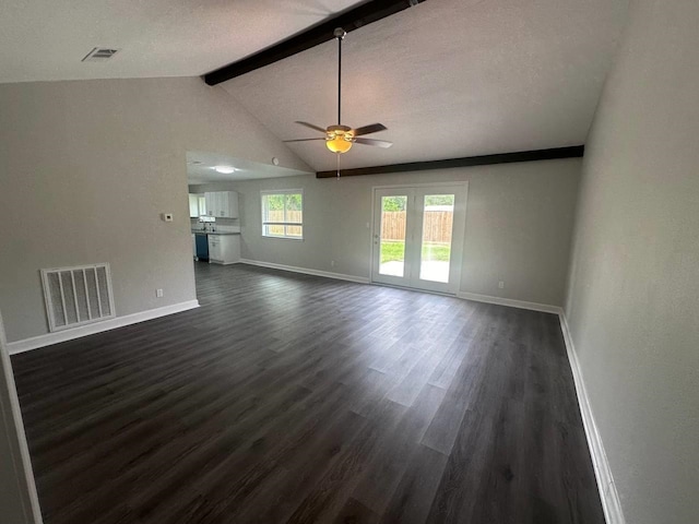 unfurnished living room with a textured ceiling, ceiling fan, lofted ceiling with beams, and dark hardwood / wood-style floors